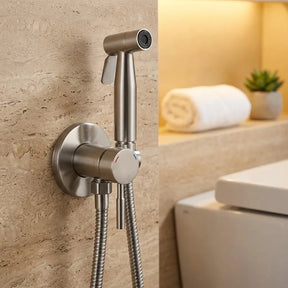 Ducha higiênica para banheiro cromado escovado instalada em parede de travertino, ambiente spa aconchegante — Toque de Casa