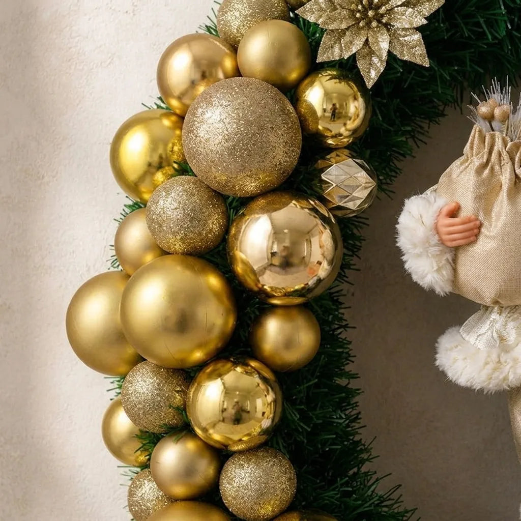 Detalhe das bolas douradas, flor e folhagem da guirlanda de Natal com Papai Noel.