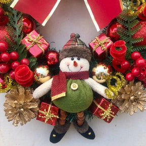 Detalhe do boneco de neve com barriga verde, cachecol vermelho, pinhas douradas e presentes da guirlanda