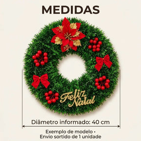 Exemplo de guirlanda sortida com flor, bagas e placa Feliz Natal, diâmetro informado de 40 cm e envio de 1 unidade.