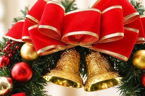 Detalhe do laço vermelho com bordas douradas e dos dois sinos da guirlanda Merry Christmas de 40 cm.
