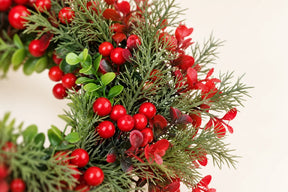 Detalhe da folhagem artificial e frutos vermelhos da guirlanda de Natal de 35 cm.