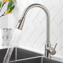 Torneira gourmet Clean em aço escovado instalada na pia com jato ducha em funcionamento