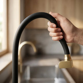 Mao dobrando a mangueira flexivel de silicone preto da torneira gourmet dourado escovado