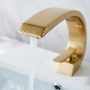 Torneira para banheiro monocomando luxury dourada escovada quente e fria, detalhe do bico com água corrente — Toque de Casa