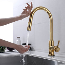 Torneira Touch 360° Dourado Brilhante instalada em bancada de cozinha, acionamento por toque na bica e água caindo na cuba