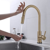 Torneira Touch 360° Dourado Escovado instalada em bancada de cozinha, acionamento por toque na bica e água caindo na cuba