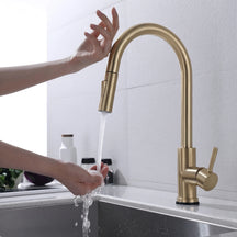 Torneira Touch 360° Dourado Escovado instalada em bancada de cozinha, acionamento por toque na bica e água caindo na cuba